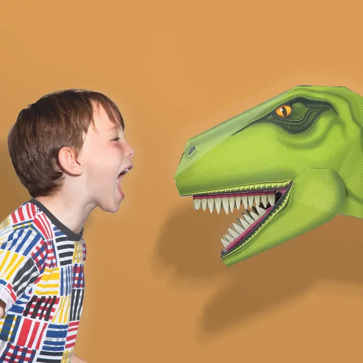 Boy happily shouting, inches away, at a 3D paper T Rex head.